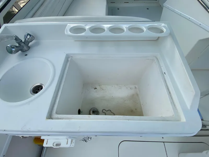 Slide: The Image of Contender 35 Express 1998 boat sink and storage area with cup holders. - 15