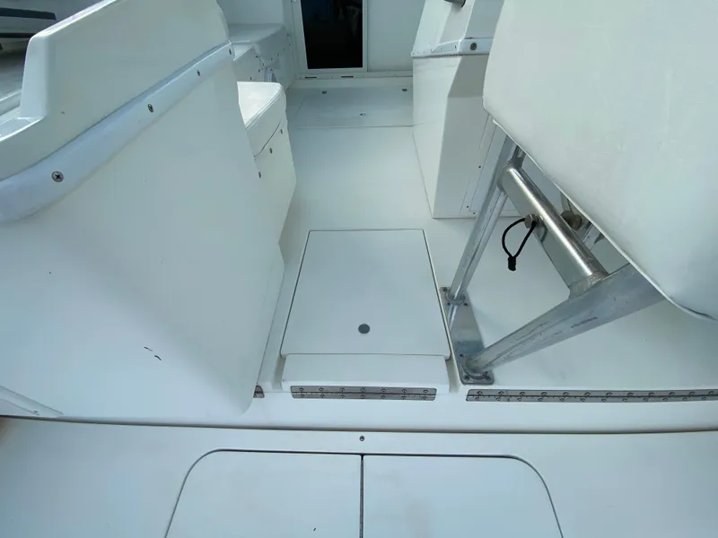 Slide: The Image of 1998 Contender 35 Express boat interior with white seating and storage compartments. - 16