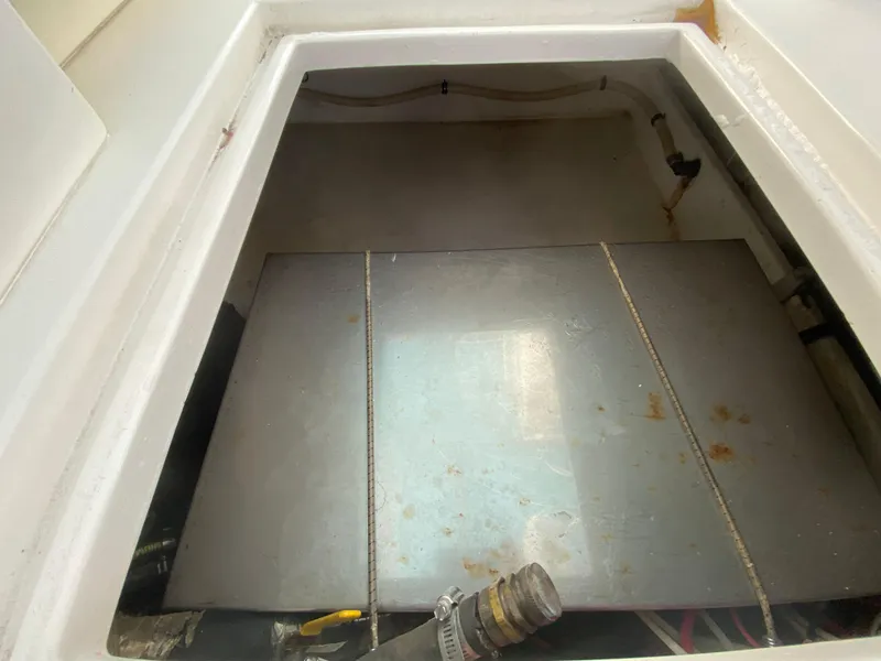 Slide: The Image of Contender 35 Express 1998 boat storage compartment with metal tank and hoses. - 17