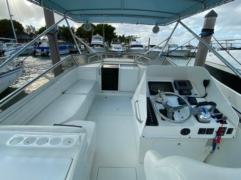 Slide: The Image of 1998 Contender 35 Express boat interior with helm, seating, and marina view. - 18