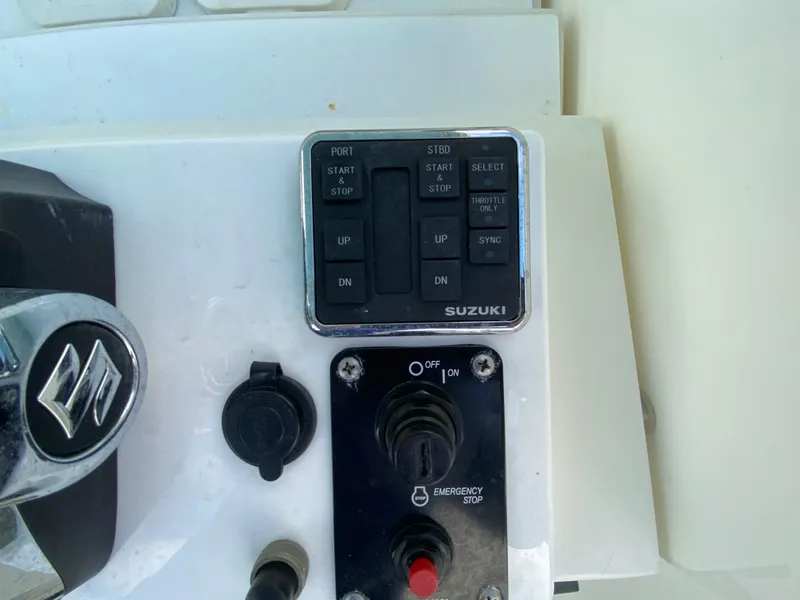 Slide: The Image of Control panel of a 1998 Contender 35 Express boat with Suzuki engine controls. - 23