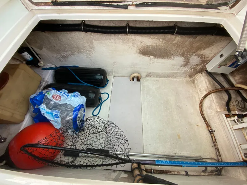 Slide: The Image of 1998 Contender 35 Express storage compartment with fishing gear and supplies. - 29