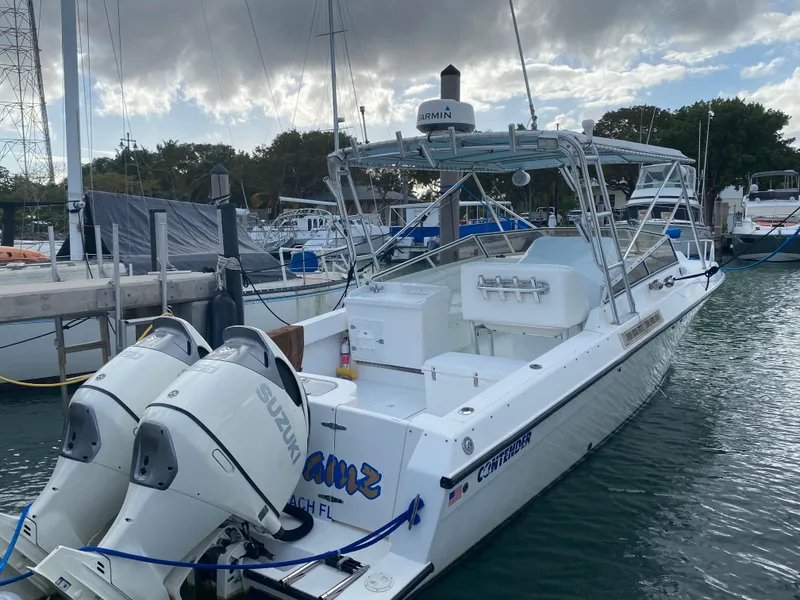 Slide: The Image of 1998 Contender 35 Express boat docked with twin Suzuki outboard engines. - 3
