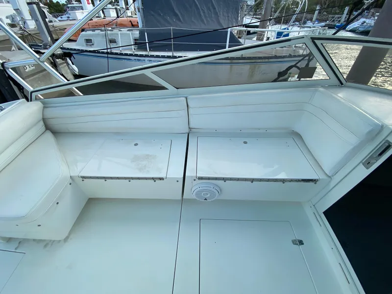 Slide: The Image of 1998 Contender 35 Express boat interior with white seating and storage compartments. - 34