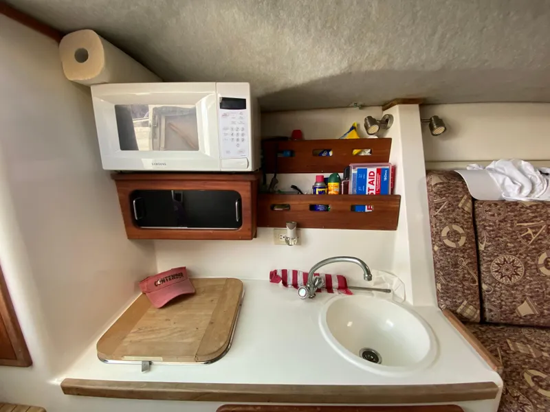 Slide: The Image of Compact kitchen area in a 1998 Contender 35 Express boat with microwave and sink. - 39