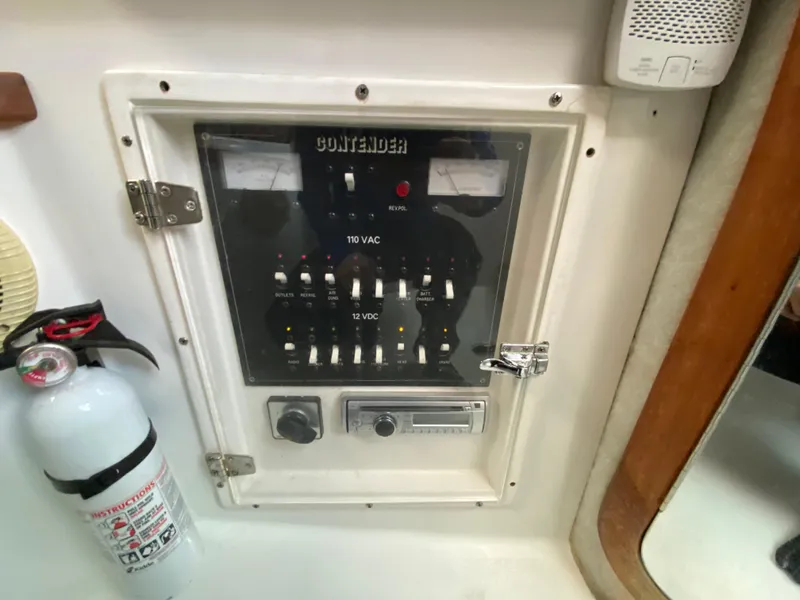 Slide: The Image of Contender 35 Express 1998 electrical panel with fire extinguisher nearby. - 40