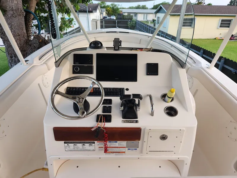 Slide: The Image of 2011 Pursuit S 280 Sport boat dashboard with steering wheel and controls. - 12