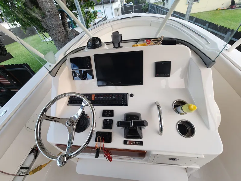 Slide: The Image of 2011 Pursuit S 280 Sport boat dashboard with steering wheel and controls. - 13