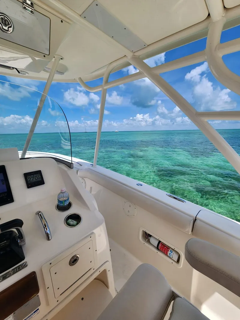 Slide: The Image of 2011 Pursuit S 280 Sport boat on clear turquoise water, sunny day, ocean view. - 21