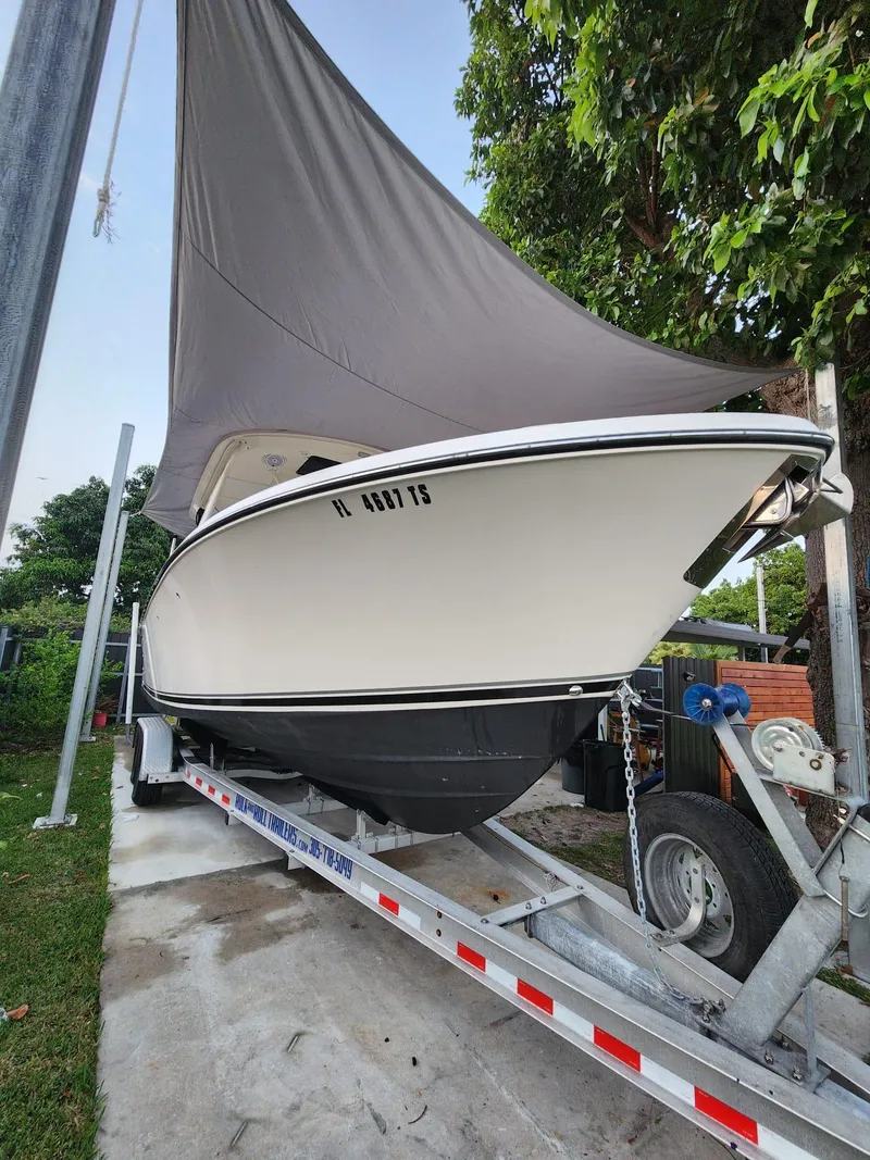 Slide: The Image of 2011 Pursuit S 280 Sport boat on trailer under tarp. - 3