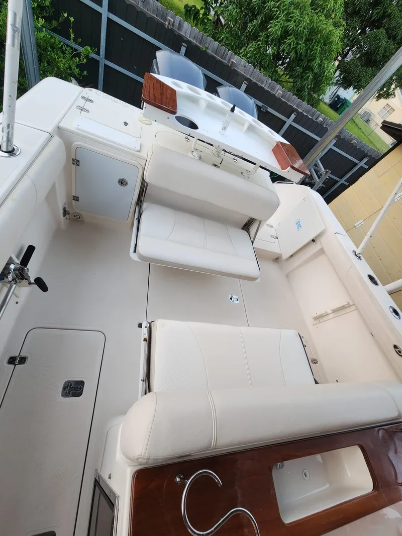Slide: The Image of 2011 Pursuit S 280 Sport boat interior with white seating and wooden accents. - 6
