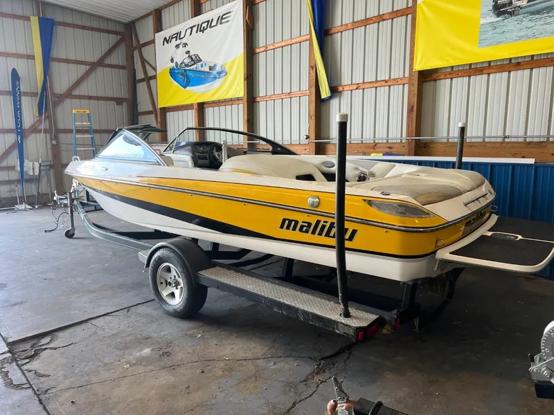 Slide: The Image of 2004 Malibu 20 Response LXI boat in a garage, yellow and white design. - 1