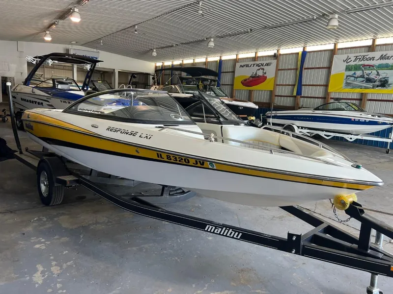 Slide: The Image of 2004 Malibu 20 Response LXI boat in showroom, white with yellow accents. - 2