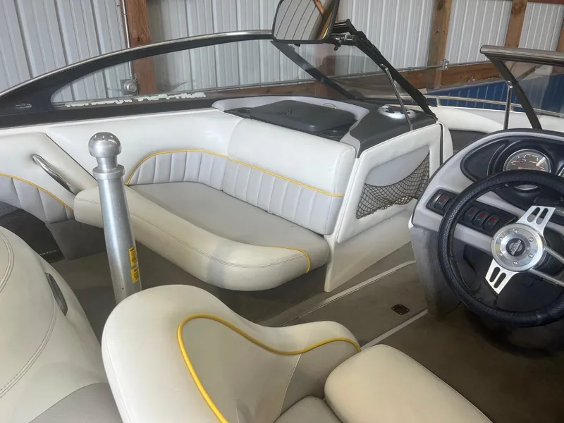 Slide: The Image of 2004 Malibu 20 Response LXI boat interior with white and yellow seating, steering wheel, and dashboard. - 7