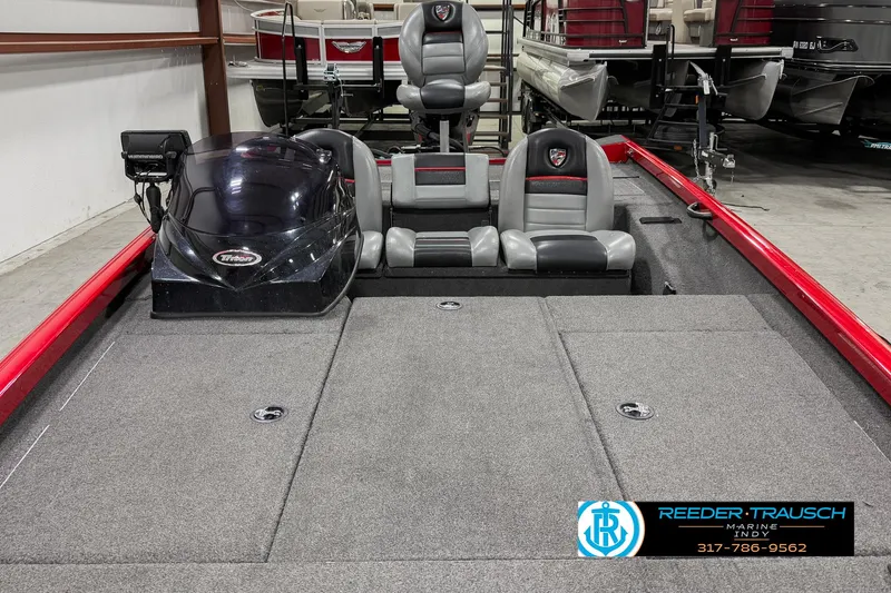 Slide: The Image of 2018 Triton 18 TX boat interior with gray seating and red accents in showroom. - 11