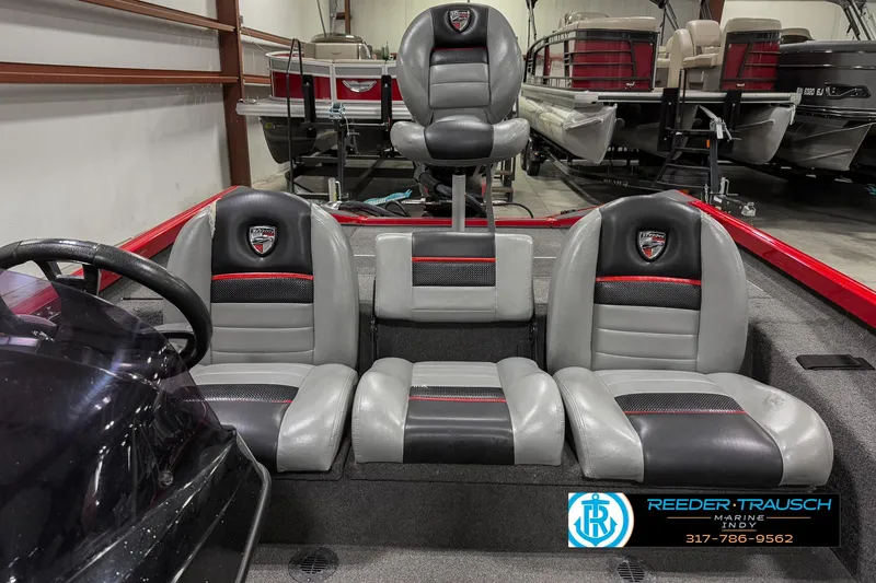 Slide: The Image of 2018 Triton 18 TX boat interior with gray and black seating in showroom. - 12