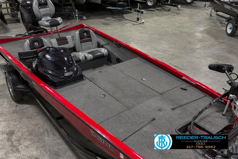 Slide: The Image of 2018 Triton 18 TX boat with red exterior and gray interior, displayed indoors. - 18