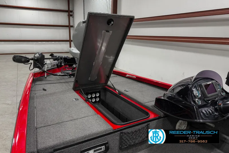 Slide: The Image of 2018 Triton 18 TX boat interior with open storage compartment in a garage. - 22