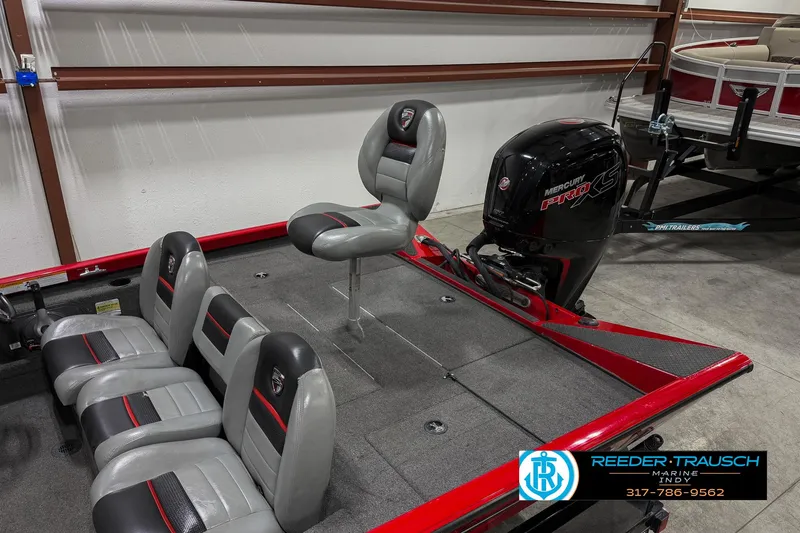 Slide: The Image of 2018 Triton 18 TX boat interior with seating and motor in showroom. - 23