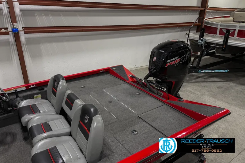 Slide: The Image of 2018 Triton 18 TX boat with seating and motor in a garage. - 24