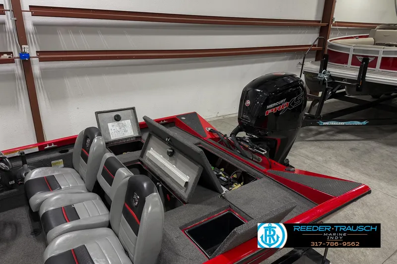 Slide: The Image of 2018 Triton 18 TX boat with seating and motor in a garage. - 25