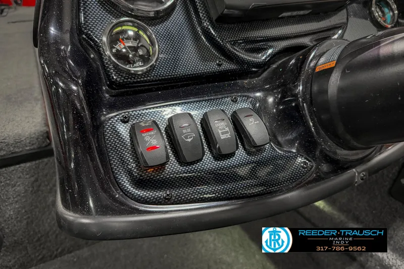 Slide: The Image of Dashboard controls of a 2018 Triton 18 TX boat with switches and gauges. - 29