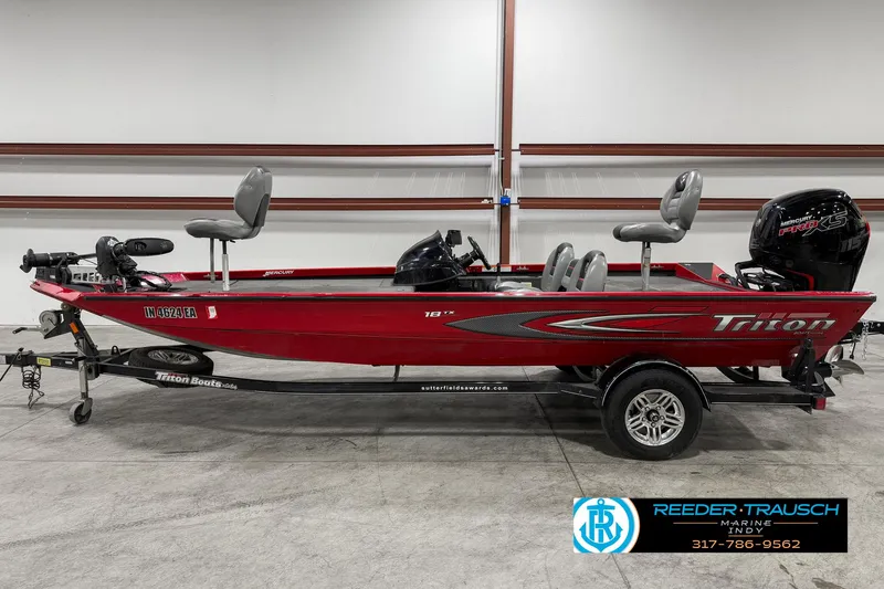 Slide: The Image of 2018 Triton 18 TX red fishing boat with trailer in showroom. - 3