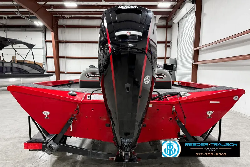 Slide: The Image of 2018 Triton 18 TX boat with Mercury engine in a warehouse setting. - 5