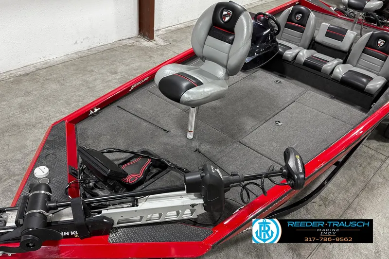 Slide: The Image of 2018 Triton 18 TX fishing boat with red trim and seating, displayed indoors. - 7