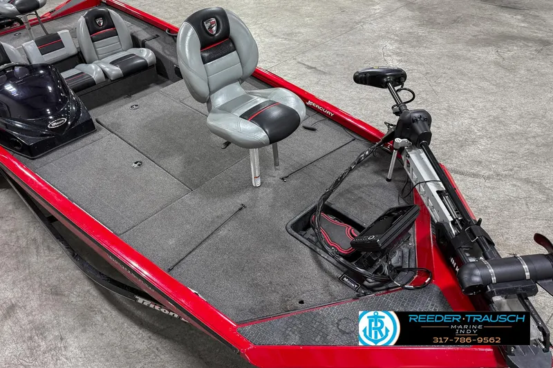 Slide: The Image of 2018 Triton 18 TX fishing boat with red and gray interior, featuring a swivel seat and trolling motor. - 8