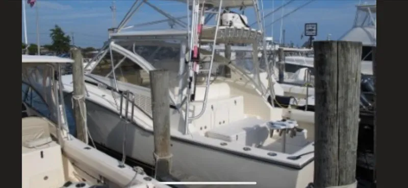 Slide: The Image of 2006 Carolina Classic 35 boat docked at a marina, featuring a spacious deck and fishing equipment. - 11