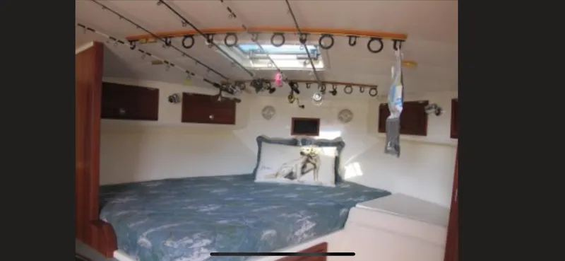 Slide: The Image of 2006 Carolina Classic 35 cabin interior with bed, fishing rods, and skylight. - 18