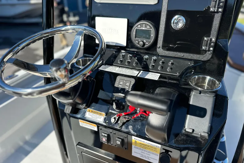Slide: The Image of 2026 Avid 23 Fusion boat dashboard with steering wheel and control panel. - 16