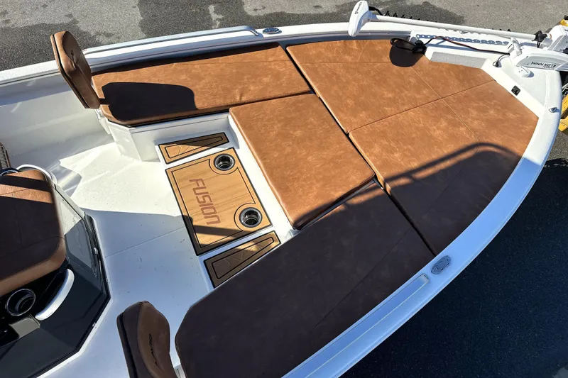Slide: The Image of Avid 23 Fusion 2026 boat interior with brown cushioned seating and Fusion branding. - 23