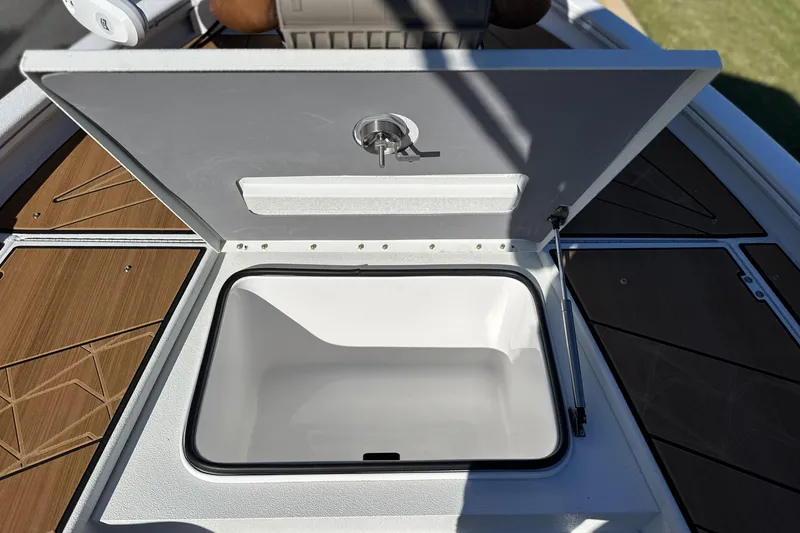 Slide: The Image of Open storage compartment on 2026 Avid 23 Fusion boat, featuring sleek design and wood accents. - 24