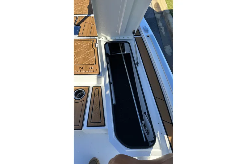 Slide: The Image of Avid 23 Fusion 2026 boat storage compartment with teak flooring and measuring scale. - 25