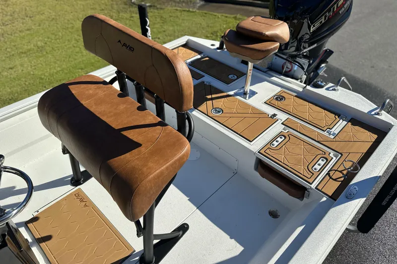 Slide: The Image of 2026 Avid 23 Fusion boat interior with brown leather seats and storage compartments. - 5