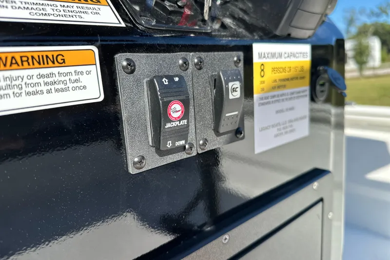Slide: The Image of Control panel on 2026 Avid 23 Fusion boat with warning labels and jackplate switch. - 6