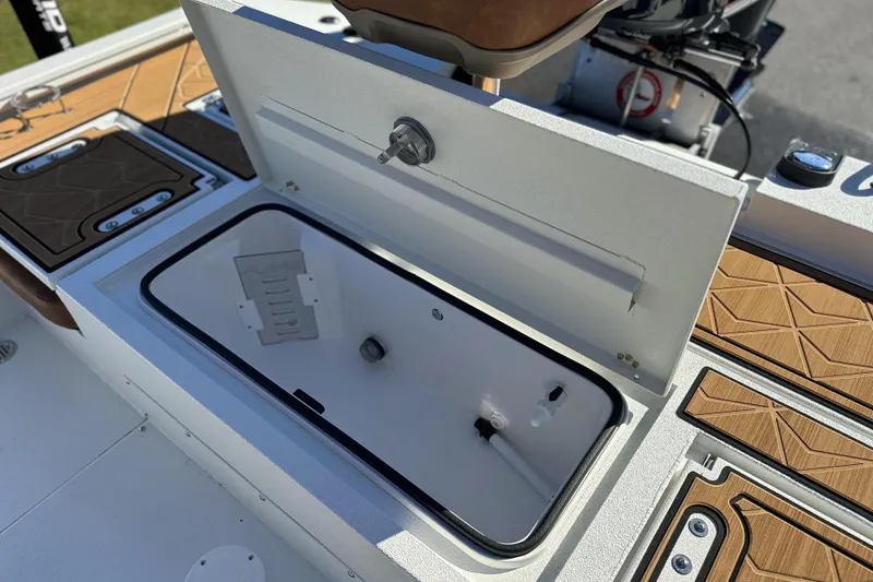 Slide: The Image of Open storage compartment on 2026 Avid 23 Fusion boat, featuring sleek design and wood accents. - 8