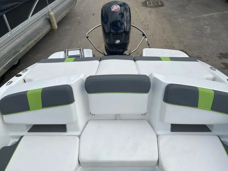 Slide: The Image of 2021 Tahoe T18 boat with gray and green seating, outboard motor visible. - 10