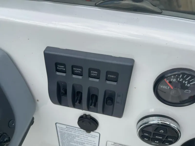 Slide: The Image of Control panel of 2021 Tahoe T18 boat with switches and voltmeter. - 16
