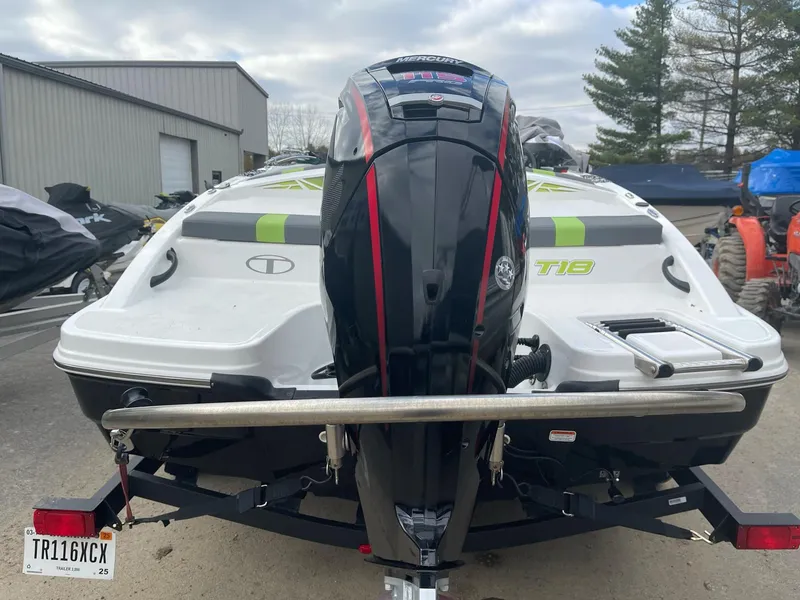 Slide: The Image of 2021 Tahoe T18 boat with outboard motor on trailer, parked outdoors. - 3