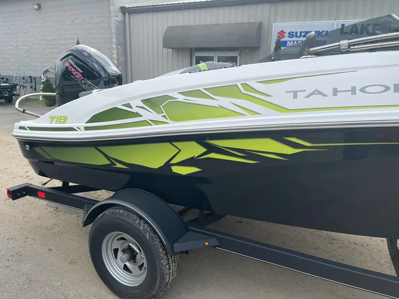 Slide: The Image of 2021 Tahoe T18 boat with vibrant green and black design on a trailer. - 5