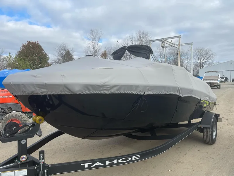 Slide: The Image of 2021 Tahoe T18 boat covered on trailer, parked outdoors. - 7
