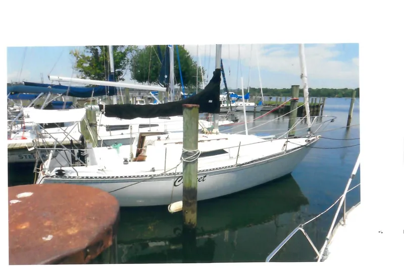 Slide: The Image of 1983 C&C 29 MkII sailboat docked at a marina, surrounded by calm water and other boats. - 2