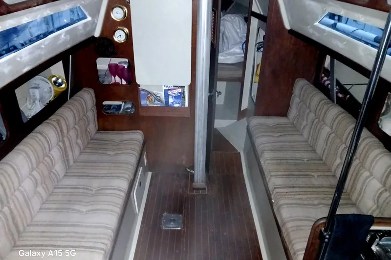 Slide: The Image of Interior of 1983 C&C 29 MkII sailboat with striped seating and wood paneling. - 5