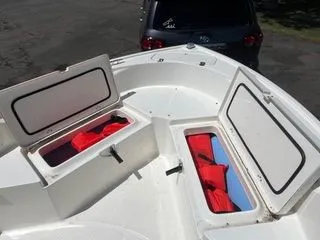 Slide: The Image of Mako 184 Center Console 2020 with open storage compartments and red life jackets. - 17