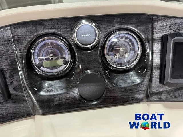 Slide: The Image of Dashboard of 2025 Tahoe LTZ 2385 Swingback with Honda gauges, Boat World logo. - 14