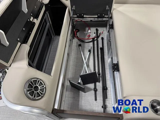 Slide: The Image of 2025 Tahoe LTZ 2385 Swingback boat storage compartment with accessories and speaker. - 24