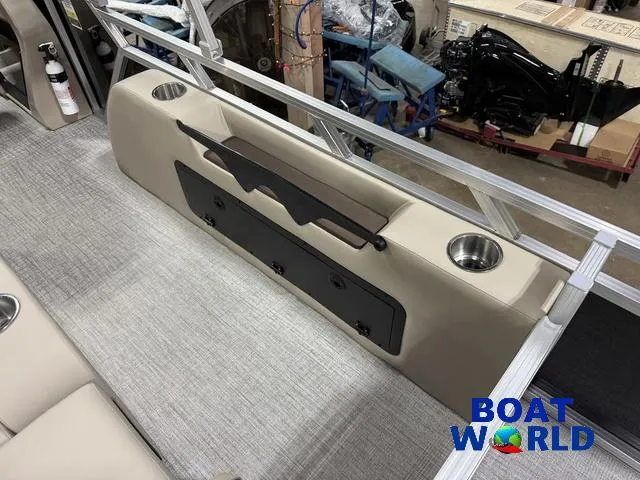 Slide: The Image of 2025 Tahoe LTZ 2385 Swingback interior with cup holders and storage, showcased by Boat World. - 26
